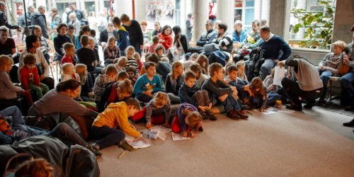 Grupa dzieci w wieku wczesnoszkolnym w czasie zajęć eduakcyjnych Muzeum Historii Polski. 